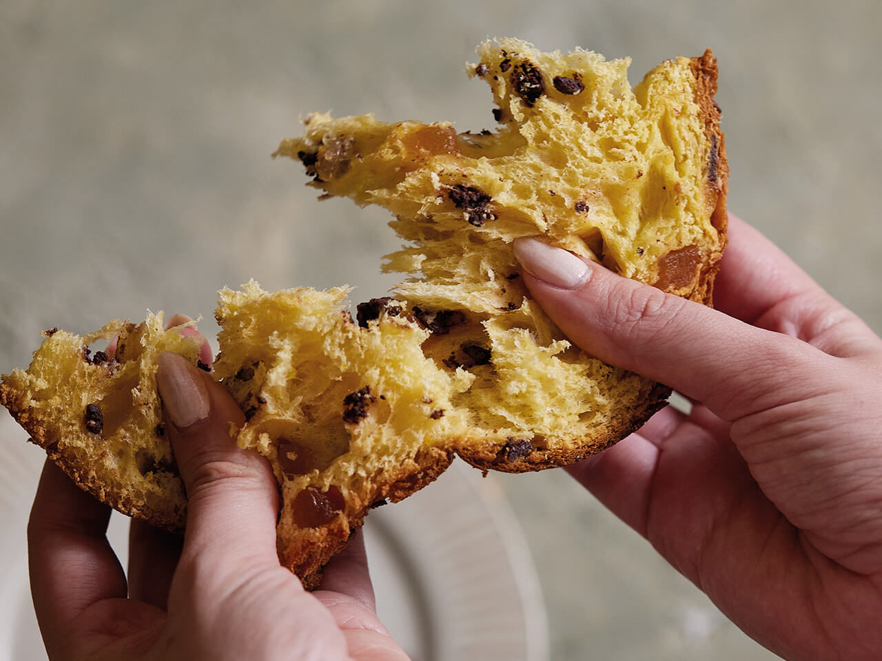 fetta di dolce di natale arancia e cioccolato aperto nella mani di una donna