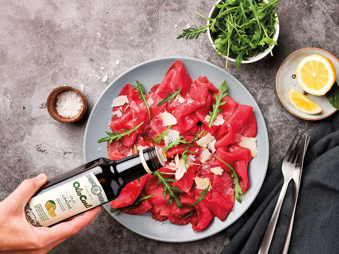 Piatto di carpaccio di cerne condita con Olio & limone Fratelli Carli