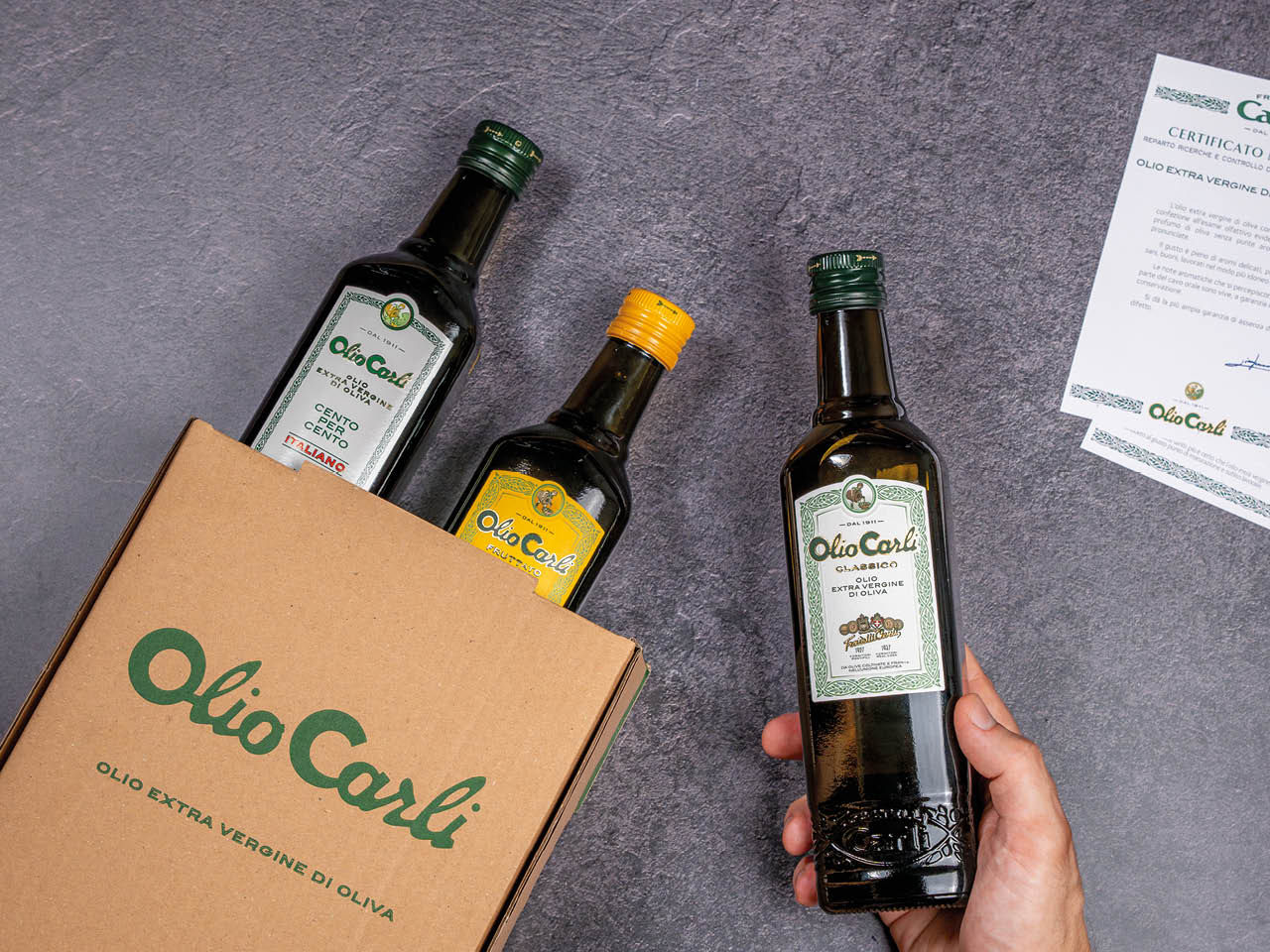 Bottiglie di Olio Carli Extra Vergine di Oliva e certificato di garanzie e qualità che le accompagna in ogni confezione